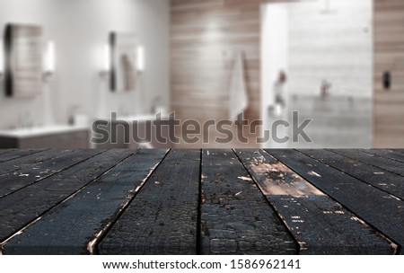 Wooden table in front of blurred bathroom interior as background.