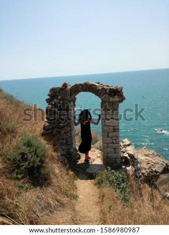 Girl, sea and the old gate