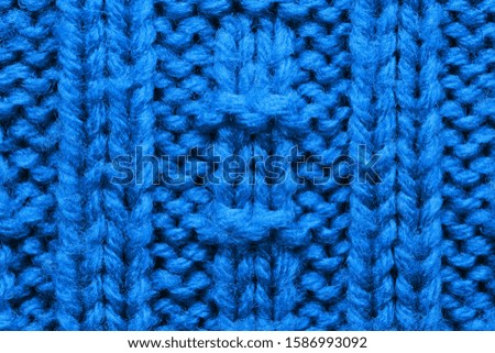 The texture of a knitted sweater. Blue pattern. Facial surface. Background. Copy space