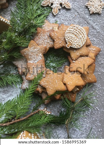 Gingerbread wreath with green tree branches on concrete background. Concept of Christmas and New Year picture and mood