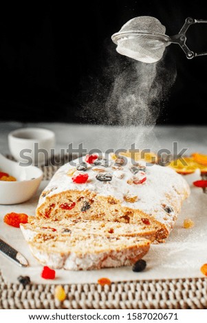 Christmas cake coated with powdered sugar. Close up hands of the chef with metal sieve sprinkling cake with Powdered sugar at pastry shop kitchen. confectioner sprinkles sugar powder confectionery