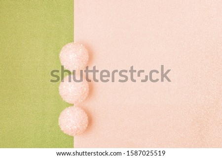 Figure on a green-pink background of lined Christmas balls
