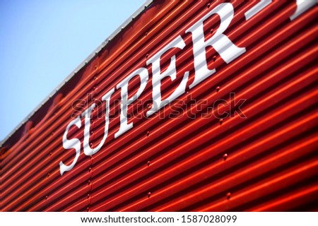 View of the word "SUPER" painted white on red surface