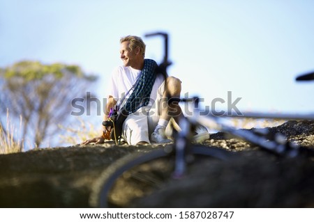 View of a man sitting on the ground with a bicycle in the foreground