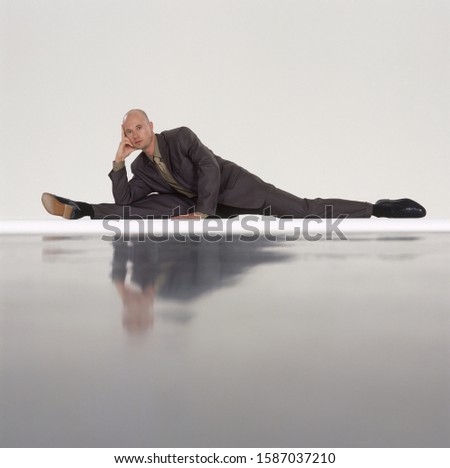 Businessman doing yoga, stretched to one side