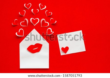 love letter with a kiss for valentines day. envelope with hearts and female lips on red background on February 14, March 8, birthday. copy space, flat lay.