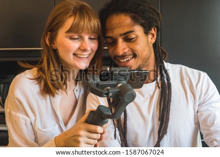 Stock photo of couple looking at the mobile in the kitchen