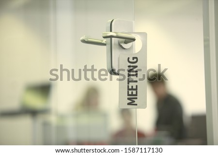 Meeting sign hanging on the doorknob