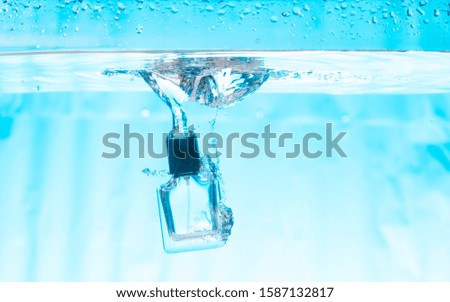 Perfume bottle with water splash and air bubbles in the water