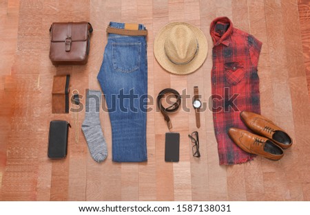 Men's casual outfits with man clothes with accessories on brown board background
