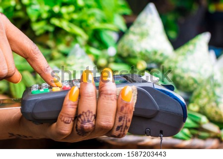 close up of an african woman selling in a local african market using a mobile point of sale device
