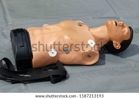 First aid training manikin lying on gray fabric