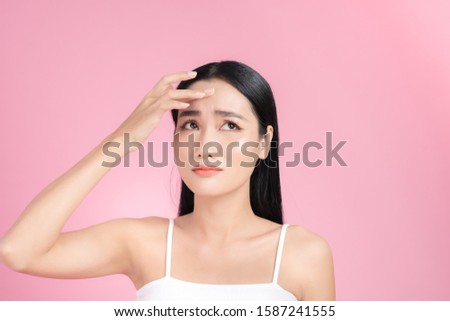 Young Asian woman touch and worry about her face. Acne, pimple, clear and clean, oily, dry skin concept.  Royalty-Free Stock Photo #1587241555