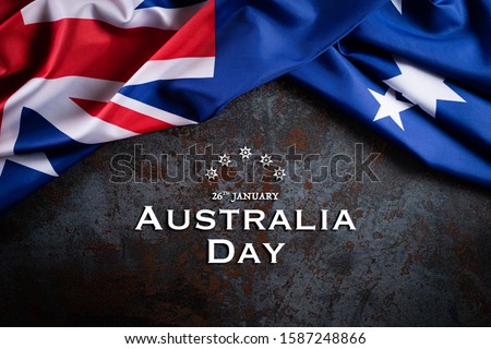Australia day concept. Australian flag with the text Happy Australia day against a black stone texture background. 26 January.
