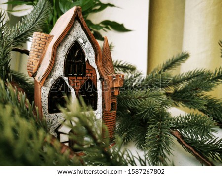 Christmas candlestick, stylized as an old half-timbered German house among spruce branches. Christmas theme. New Yaer card