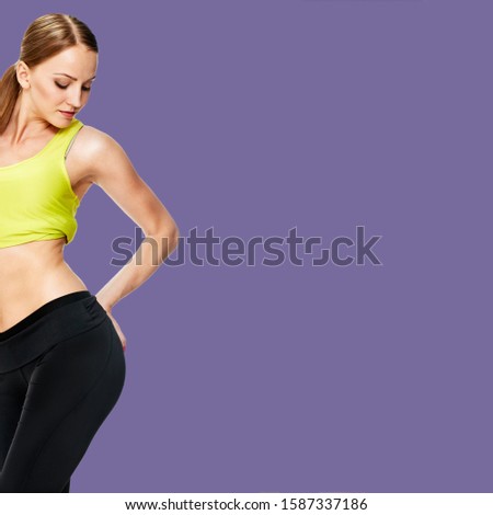 picture of sporty woman checking her hips on background royal shade violet
