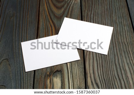 Two blank cards (business cards, tickets, flyers, invitations, coupons, banknotes, etc.) on dark wooden background