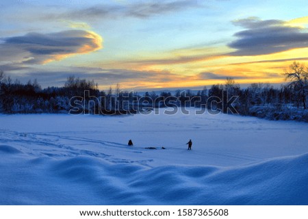 The winter landscape. Evening twilight. Children play in the snow. Winter fun. At sunset.