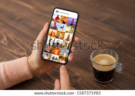 Woman browsing photos on social media app, person's name on screen is made up Royalty-Free Stock Photo #1587371983