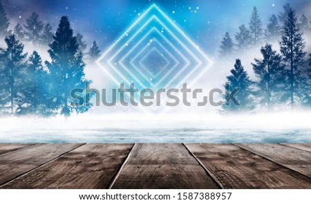 Winter background. Winter snow landscape with wooden table in front. Dark winter forest background at night. Snow, fog, moonlight. Dark neon night background in the forest with moonlight.