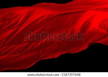 Red Cloth fly in the air, Reddish satin fabric throws like strong wind wave with studio lighting, Wallpaper Background Texture Detail of black backgrounds