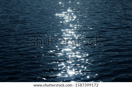 Sea texture. sunlight twinkling and reflecting off lake water. water glistening from the sunlight hitting the water, with ripples and light rays bouncing off the surface, hope, faith and happiness Royalty-Free Stock Photo #1587399172