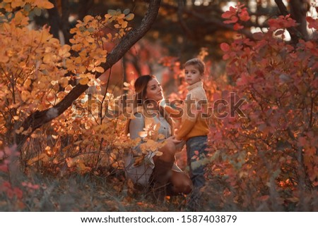 mother and son walk together in the Park in autumn in warm clothes.