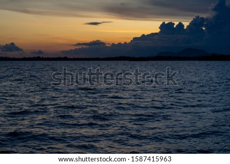 Water ripples and sunset in the background in the open sea with beautiful clouds.