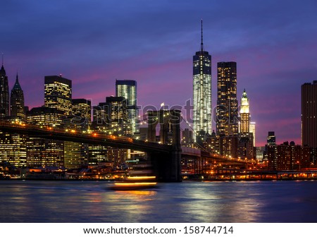 Brooklyn Bridge, East River and Manhattan at night with lights and reflections. New York City