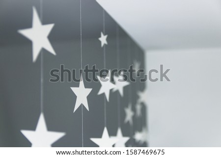 Krafted white paper stars on strings rope