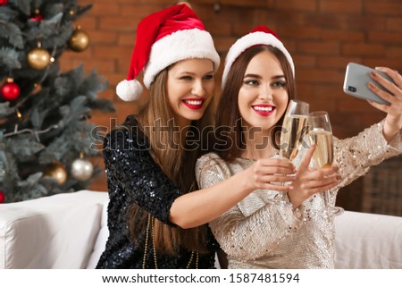 Beautiful young women taking selfie at Christmas party