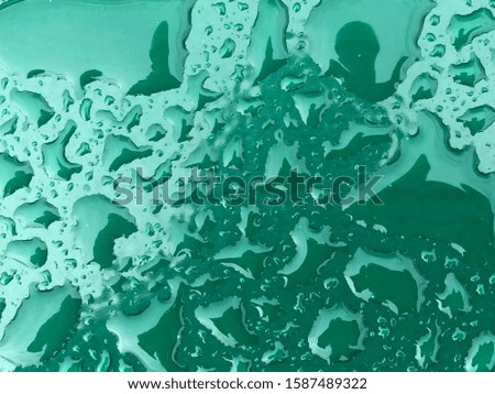 Rain drops on green colored metal surface