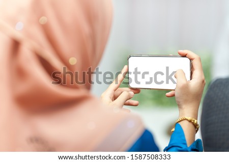 Asian Muslim women use a new generation of smart phones product photography Within the annual trade show To develop the online sales business to be fast and in time for the world
