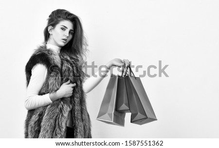 Sales and discount on black friday. Fashionista buy clothes in shop. Girl makeup face wear fur vest white background. Woman shopping luxury boutique. Lady hold shopping bags. Shopping concept.