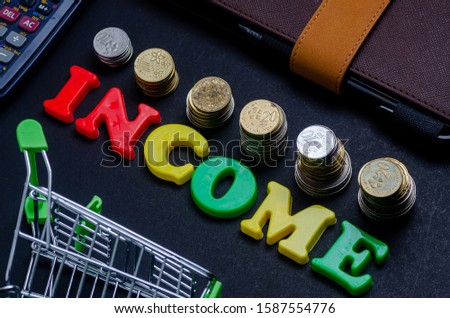income letters with coins and props over the black background