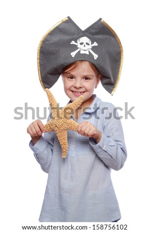 Portrait of a happy cheerful little girl in a pirate hat holding a large exotic starfish isolated on a white Halloween/Beautiful smiling child dressed as a pirate with a starfish in his hand