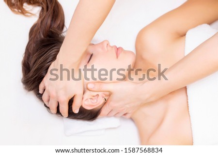 massage and stretching of the cervical muscles. Beautiful girl gets massage in a spa salon. light tones photos. concept of massage and health. rheumatism, arthrosis