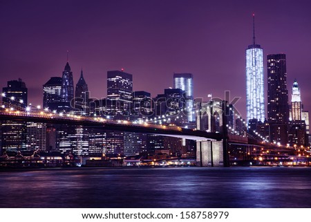 The Brooklyn Bridge on a Colorful Night. Photo features the NYC skyline and One World Trade Center