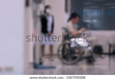 Blurry image. Background of blurred  a man sit on wheelchair with nurse waiting for treatment in hospital. Healthy care or family relationship concept.