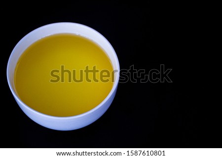 Natural fresh healty vegetable oil in white bowl, oil for cooking healty food, isolated on black background. top view.copy space