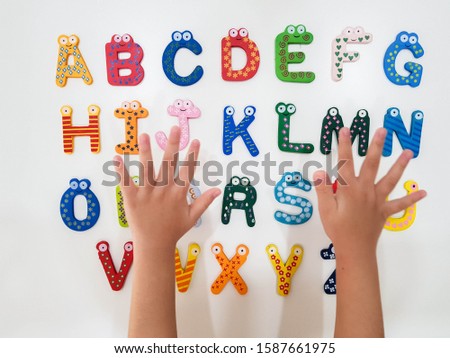 The alphabet wooden block set with the kid hand arranging the  alphabetical order.