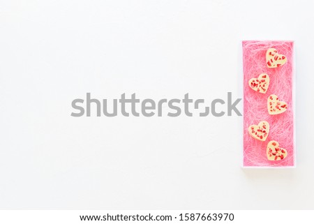 Candy hearts made of white chocolate and sublimated strawberries in a box. Horizontal orientation, copy space.