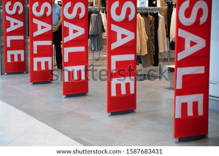 Red sale signs at clothes shop entrance