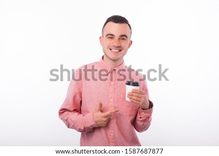 Portrait of smiling man pointing at cup of coffee