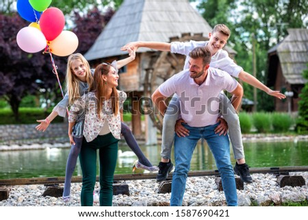 Mom, dad and their kids goofing around while posing for pictures