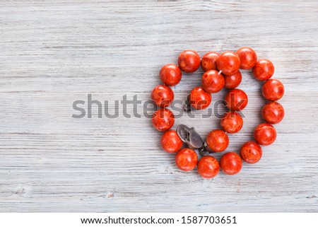 top view of vintage red coral necklace on gray wooden board with copyspace Royalty-Free Stock Photo #1587703651