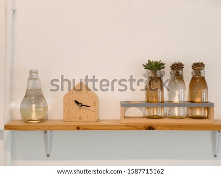 Cactus in bottle with wooden clock on Wooden base for cafe background.