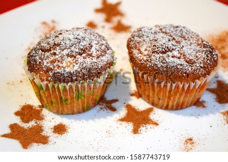 Christmas muffins with cinnamon and apple arranged in white plate among stars