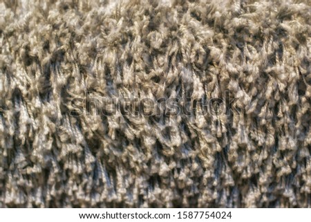 Texture of long-pile carpet. Abstract background of a shaggy grey carpet pile texture with long fibers.