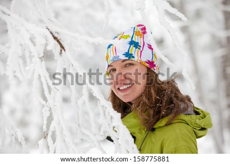 Young woman posing at camera in winter mountains